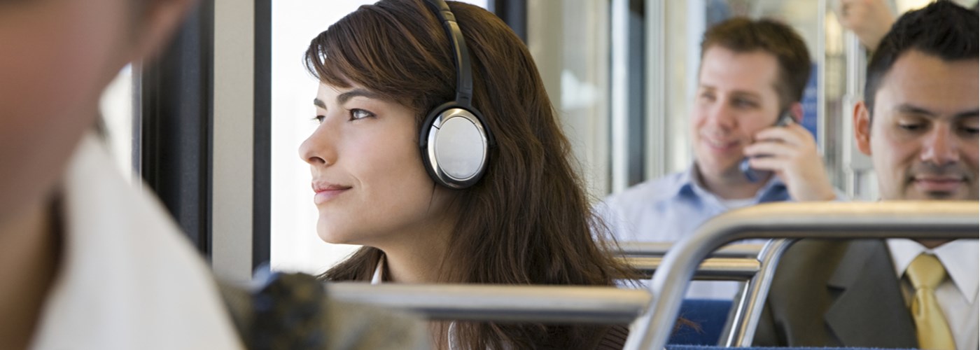 Woman listening to headphones on public transport