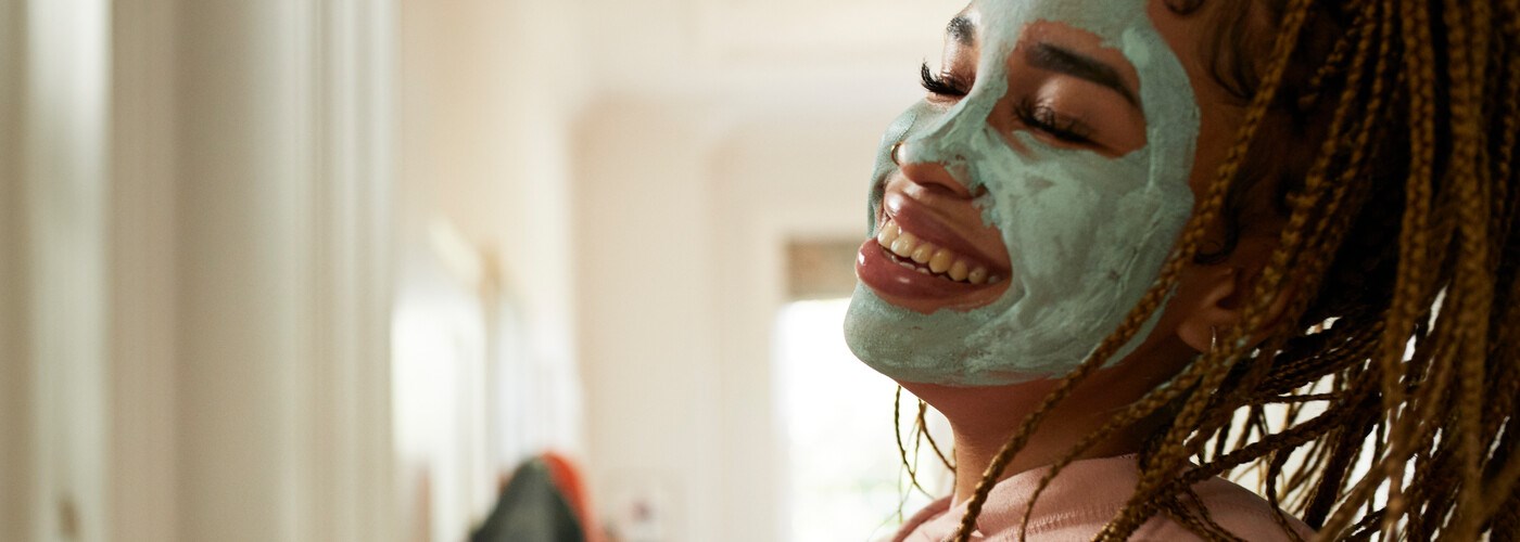 Young woman happy wearing a skincare mask