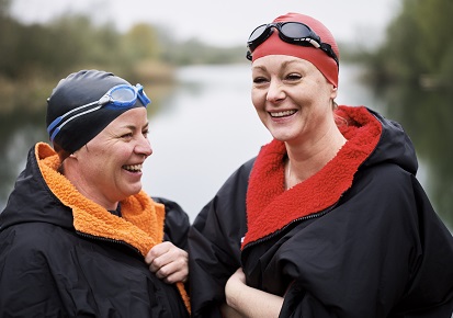 Two ladies bundled up after wild swimming