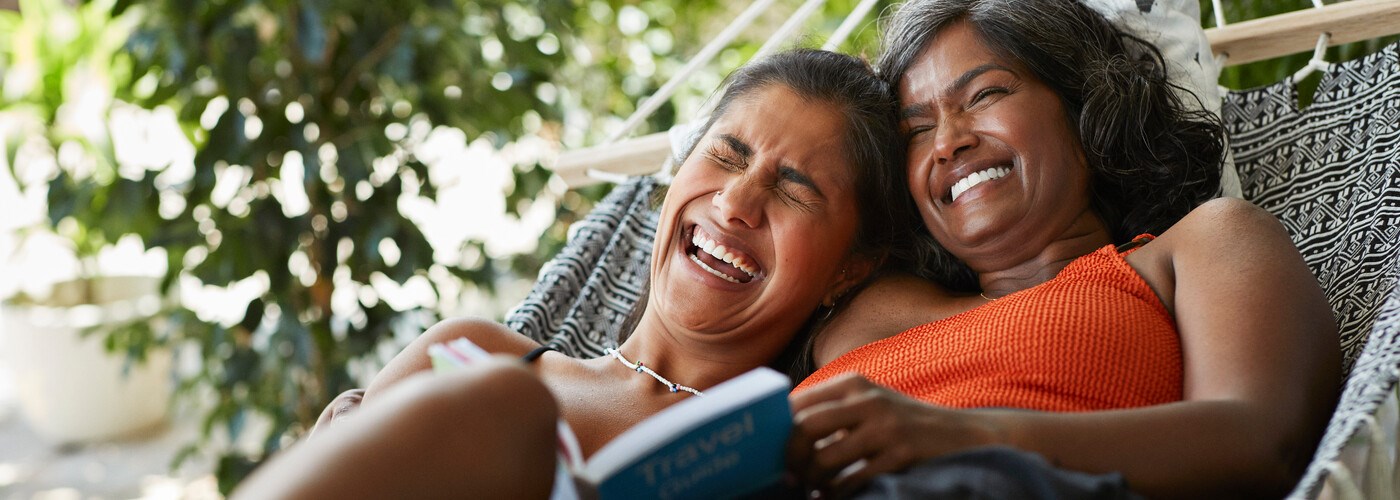 Two ladies laughing in a hammock